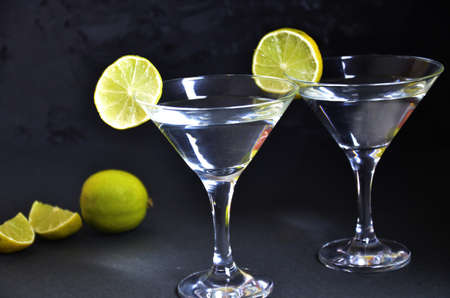 Two glasses for making margarita cocktails with lime on a blackの写真素材