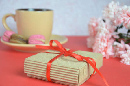 Mothers day or women's Day concept - box with a gift a beige cup of cappuccino beautiful white-pink...