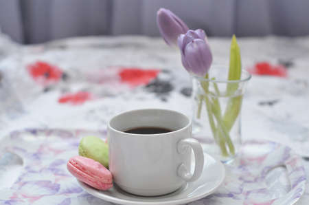 Tray with paper sketchbook, smartphone and spring flowers on pink bedding. Relaxing, or working, or writing diary or blog in bed at home. with tablet.の写真素材