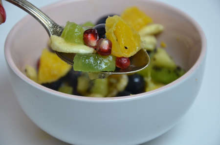 fresh fruit spoon Diet, healthy fruit salad in the white bowl - healthy breakfast, weight loss concept.の写真素材