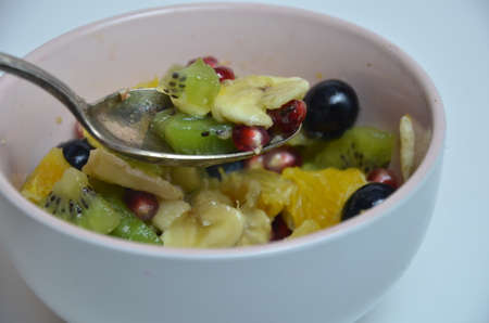 fresh fruit spoon Diet, healthy fruit salad in the white bowl - healthy breakfast, weight loss concept.の写真素材