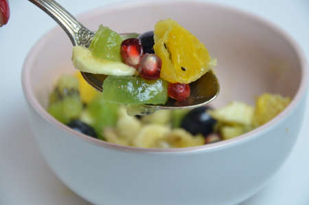 fresh fruit spoon Diet, healthy fruit salad in the white bowl - healthy breakfast, weight loss concept.の写真素材