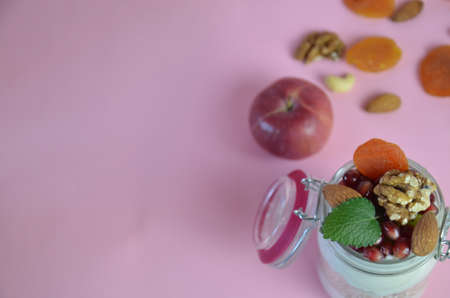 Healthy breakfast overnight oats with fresh berries in a glass jar with dried fruits, apple and nuts, walnuts, almonds. with yogurt, cottage cheese, pudding. diet, keto diet.の写真素材