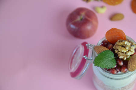 Healthy breakfast overnight oats with fresh berries in a glass jar with dried fruits, apple and nuts, walnuts, almonds. with yogurt, cottage cheese, pudding. diet, keto diet.の写真素材