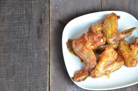 plate of chicken wings on brown wooden table.の写真素材