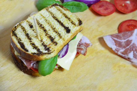Top view of Healthy grilled Sandwich toast with lettuce, ham, cheese and tomato on a wooden background. close upの写真素材