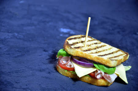 Top view of Healthy grilled Sandwich toast with lettuce, ham, cheese and tomato on a dark black background. close upの写真素材