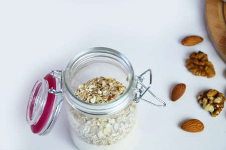 Healthy breakfast overnight oats with fresh berries in a glass jar with dried fruits, apple and nuts, walnuts, almonds. with yogurt, cottage cheese, pudding. diet, keto diet.の写真素材