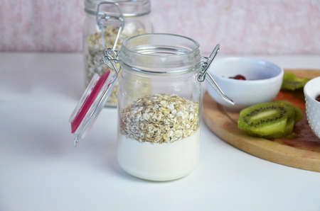 Healthy breakfast overnight oats with fresh berries in a glass jar with dried fruits, apple and nuts, walnuts, almonds. with yogurt, cottage cheese, pudding. diet, keto diet.の写真素材