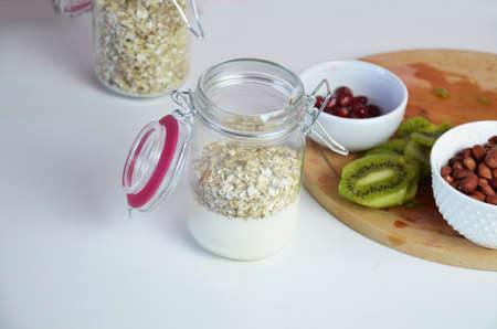 Healthy breakfast overnight oats with fresh berries in a glass jar with dried fruits, apple and nuts, walnuts, almonds. with yogurt, cottage cheese, pudding. diet, keto diet.の写真素材