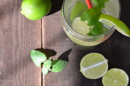 Mojito cocktail on black background with lime and mint with copy space alcoholic or non-alcoholic drink at the bar. summer refreshing cocktail with ice cubes. on dark woodenの写真素材