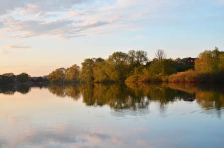 Beautiful colorful sunset over Lake in the forest or park with tree.の写真素材