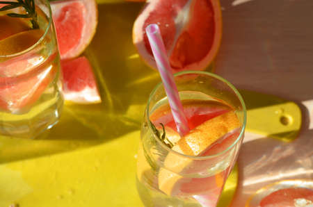Girl cooking healthy detox smoothie with fresh fruits and green rosemary grapefruit water. Lifestyle...