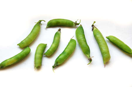 green peas in pods on a white backgroundの写真素材