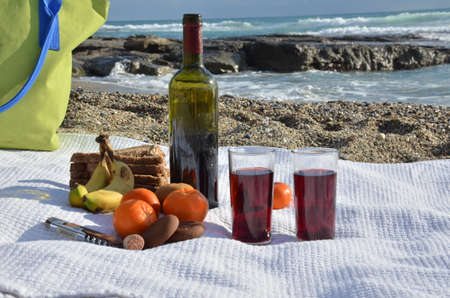 A party on the beach at sunset with wine. Romantic day evening in the summer by the sea. Picnic. copy space,の写真素材