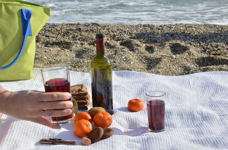 A party on the beach at sunset with wine. Romantic day evening in the summer by the sea. Picnic. copy spaceの写真素材