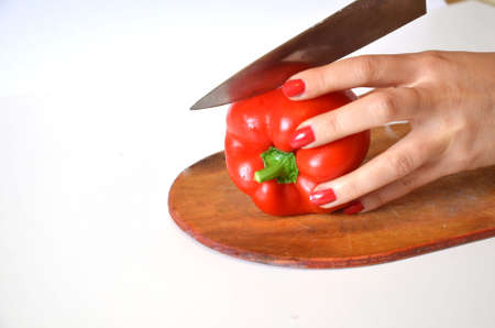 red sweet pepper on a cutting board. cut by knifeの写真素材