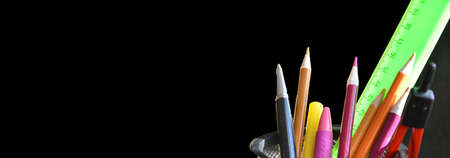 Back to school. pens, pencils, brushes in a glass against the background of a blackboard. School background with space for your text. bannerの写真素材