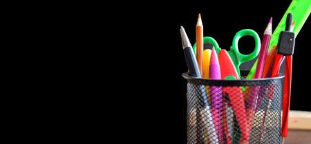 Back to school. pens, pencils, brushes in a glass against the background of a blackboard. School background with space for your text. bannerの写真素材