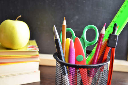 Back to school. pens, pencils, brushes in a glass against the background of a blackboard. School background with space for your textの写真素材