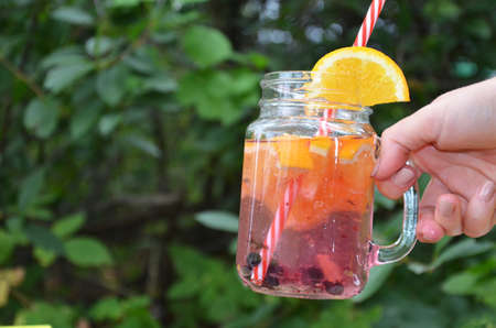 Infused detox water with orange, blueberry and mint. Ice cold summer cocktail or lemonade in glass mason jar, diet, body cleansing, healthy lifestyleの写真素材