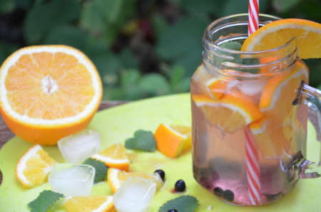 Infused detox water with orange, blueberry and mint. Ice cold summer cocktail or lemonade in glass mason jar, diet, body cleansing, healthy lifestyleの写真素材