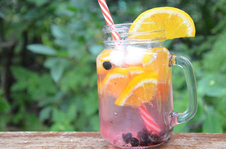Infused detox water with orange, blueberry and mint. Ice cold summer cocktail or lemonade in glass mason jar, diet, body cleansing, healthy lifestyleの写真素材