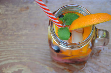Infused detox water with orange, blueberry and mint. Ice cold summer cocktail or lemonade in glass mason jar, diet, body cleansing, healthy lifestyleの写真素材