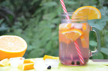 Infused detox water with orange, blueberry and mint. Ice cold summer cocktail or lemonade in glass mason jar, diet, body cleansing, healthy lifestyleの写真素材