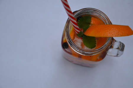 Infused detox water with orange, blueberry and mint. Ice cold summer cocktail or lemonade in glass mason jar, diet, body cleansing, healthy lifestyleの写真素材