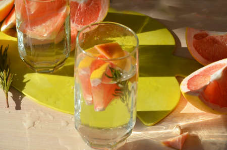 Girl cooking healthy detox smoothie with fresh fruits and green rosemary grapefruit water. Lifestyle detox conceptの写真素材