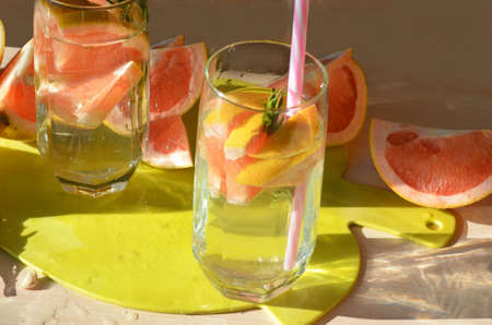 Girl cooking healthy detox smoothie with fresh fruits and green rosemary grapefruit water. Lifestyle detox conceptの写真素材