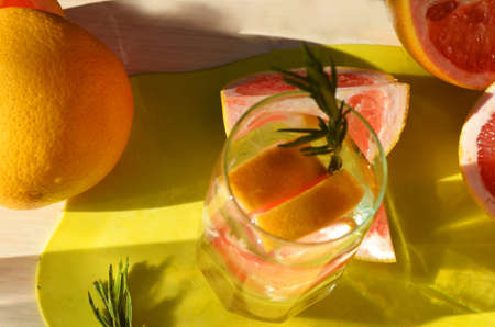 Girl cooking healthy detox smoothie with fresh fruits and green rosemary grapefruit water. Lifestyle detox conceptの写真素材