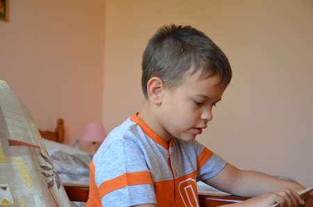 Boy reading book side view.