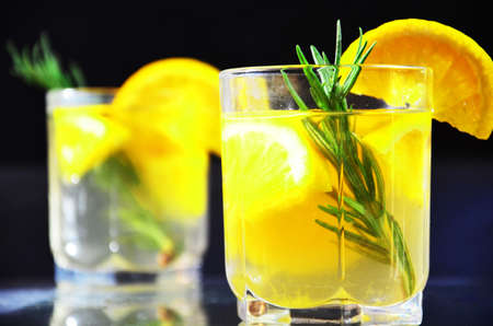 glasses of honey bourbon cocktail with rosemary whiskey sour drink with orange peel, or winter warmer drink punch or mulled wine christmas party cocktail or detox, healthy drink for diet, vitamin cの写真素材