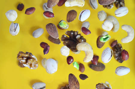Nuts in the air on a yellow background, flying nuts. Healthy Brain Food, Diet, Protein, Almonds, walnuts and hazelnuts peanut, cashews, pistachiosの写真素材