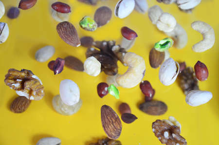 Nuts in the air on a yellow background, flying nuts. Healthy Brain Food, Diet, Protein, Almonds, walnuts and hazelnuts peanut, cashews, pistachiosの写真素材