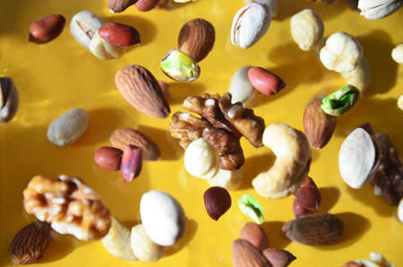 Nuts in the air on a yellow background, flying nuts. Healthy Brain Food, Diet, Protein, Almonds, walnuts and hazelnuts peanut, cashews, pistachiosの写真素材