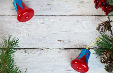 Christmas or new year composition. Christmas gift, two Christmas decorations red blue bell, pine cones, fir branches on wooden white background. Flat lay, top view, copy spaceの写真素材
