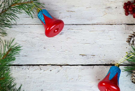 Christmas or new year composition. Christmas gift, two Christmas decorations red blue bell, pine cones, fir branches on wooden white background. Flat lay, top view, copy spaceの写真素材