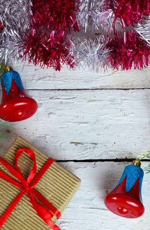 Christmas or new year composition. Christmas gift, two Christmas decorations red blue bell, pine cones, fir branches on wooden white background. Flat lay, top view, copy spaceの写真素材