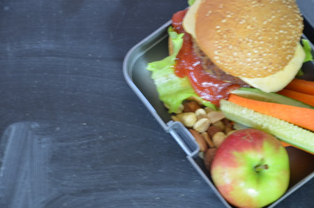 Homemade Hamburgers with lettuce in lunchbox. with orange juice. banana nuts. vegetables carrots and cucumber. On the school black board. Snack. School lunch. back to school. top view copy spaceの写真素材