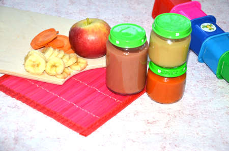 baby food, baby fruit mashed in a glass jar, sliced carrot slices, apple, bananaの写真素材