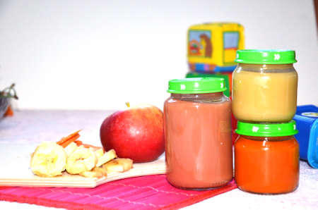 baby food, baby fruit mashed in a glass jar, sliced carrot slices, apple, bananaの写真素材