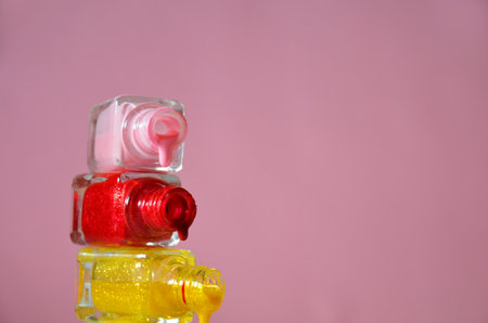 Bottles with spilled nail polish over pink red background cosmetology, beauty salon, manicure, cosmeticsの写真素材