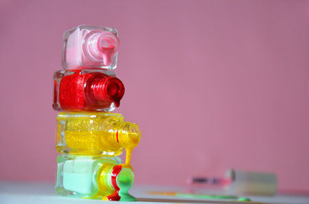 Bottles with spilled nail polish over pink red background cosmetology, beauty salon, manicure, cosmeticsの写真素材