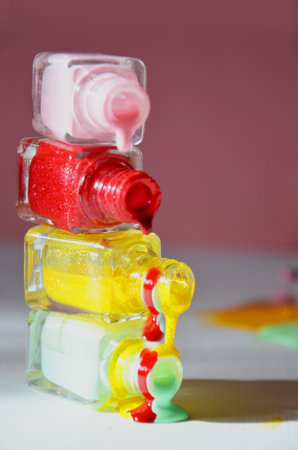 Bottles with spilled nail polish over pink red background cosmetology, beauty salon, manicure, cosmeticsの写真素材