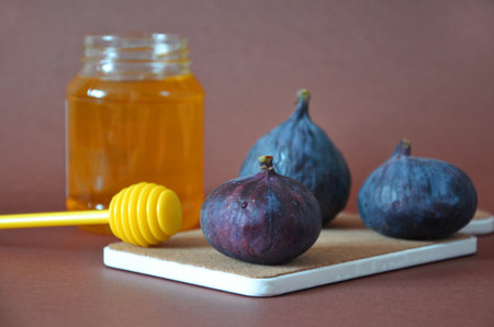 ripe figs with honey and walnuts on a brown background, ingredients for a healthy breakfast, no sugar, diet. Healthy breakfast of superfoods, quinoa, honey, nuts, figs, coffee. Top viewの写真素材