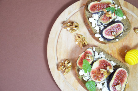 Sandwiches with ricotta, fresh figs, walnuts and honey. Canape or crostini with toasted baguette, cheese, jam, Delicious appetizer, ideal as an aperitif. Selective focusの写真素材