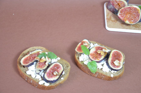 Sandwiches with ricotta, fresh figs, walnuts and honey. Canape or crostini with toasted baguette, cheese, jam, Delicious appetizer, ideal as an aperitif. Selective focusの写真素材